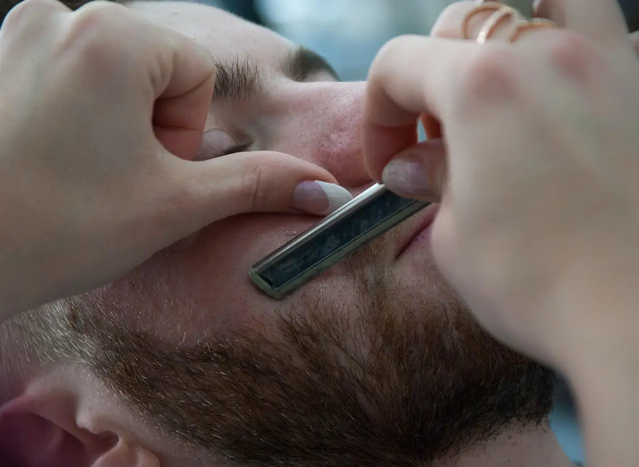 A young person learning barbering technique in a training chair