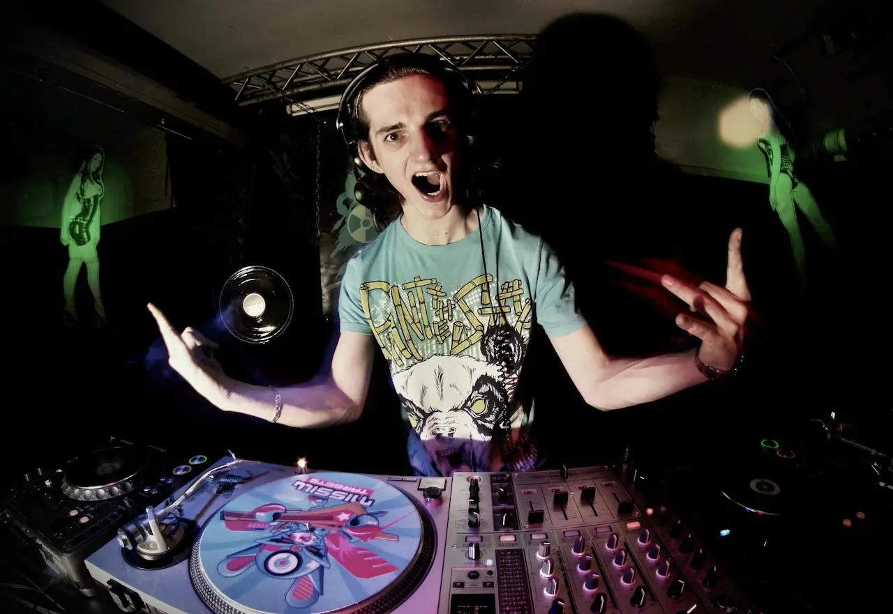 A young person working at DJ decks and a music production setup