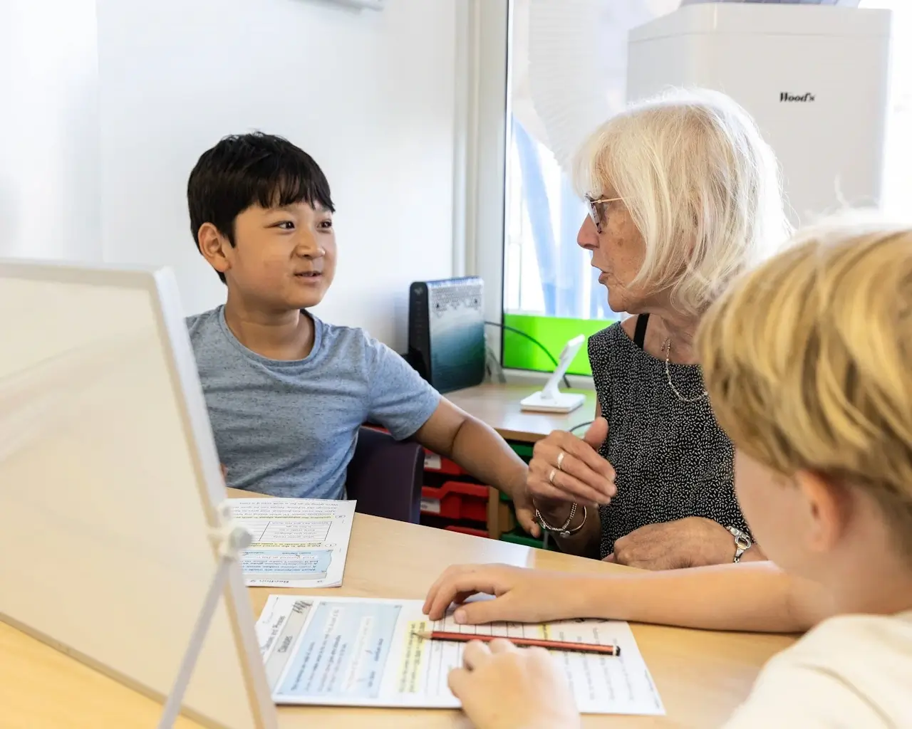 A primary-age learner working through a Mathematics activity with an adult alongside